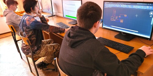 Uczniowie pracują nad projektem przy komputerach