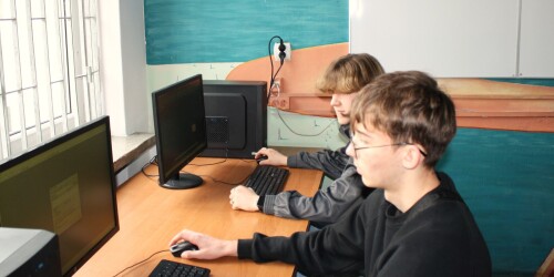 Uczniowie siedzący przy komputerach i pracujący w programie AutoCad