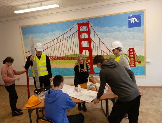 Technik budownictwa - uczniowie na tle malunku mostu w sali budownictwa