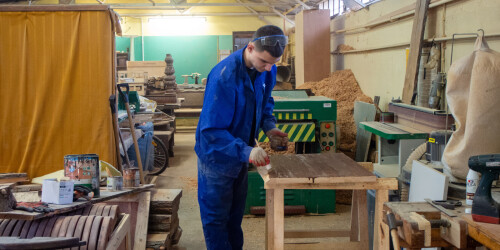 Uczeń pracujący przy maszynie do obróbki drewna