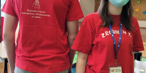 Uczennika i uczeń w czerwonej koszulce promują akcję krwiodawstwa