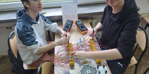 Uczniowie dokonują pomiarów elektrycznych silnika
