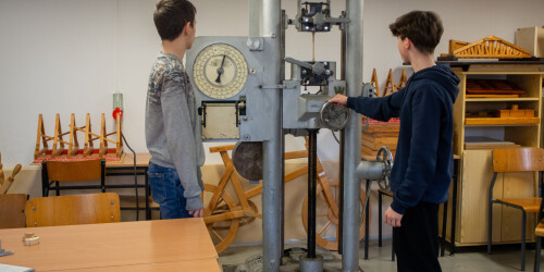 Uczniowie obsługują maszynę do badania twardości drewna